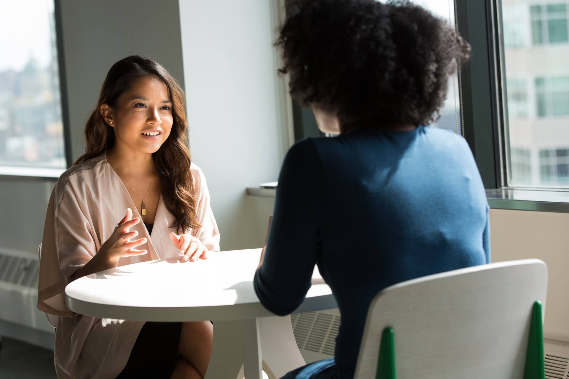 Marketing Ideas For Your Small Business Two person wearing formal attire talking to each other with a white round table in between.
